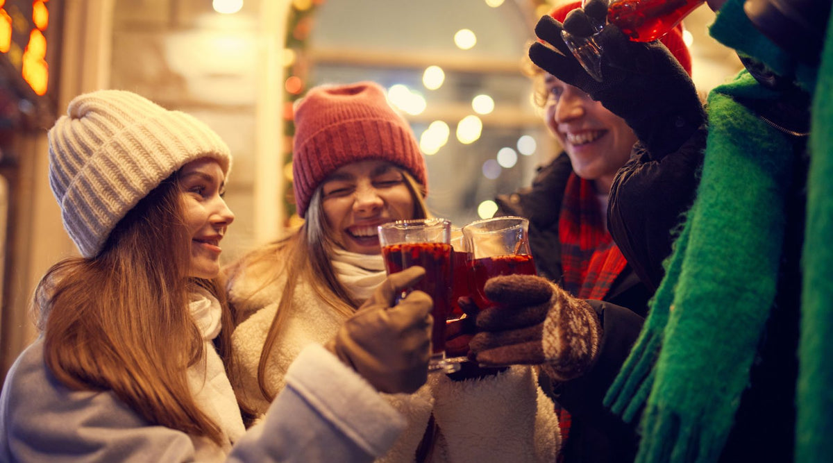 Drei Frauen halten Glühwein in der Hand