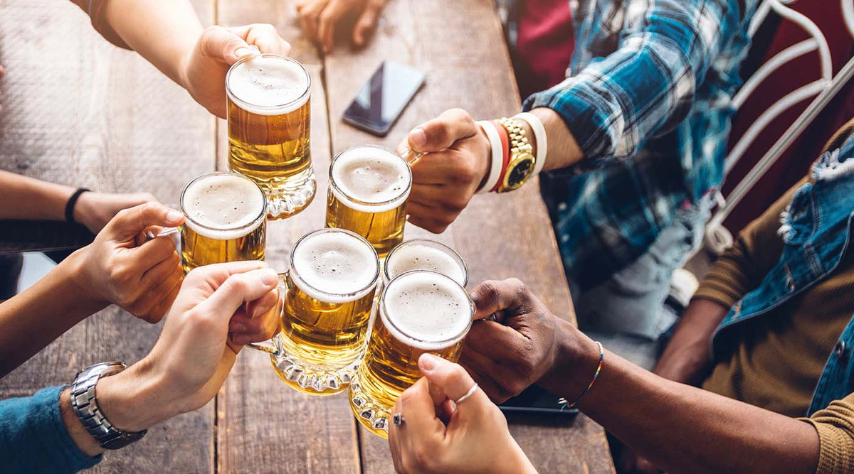 Personen stoßen mit Biergläsern an
