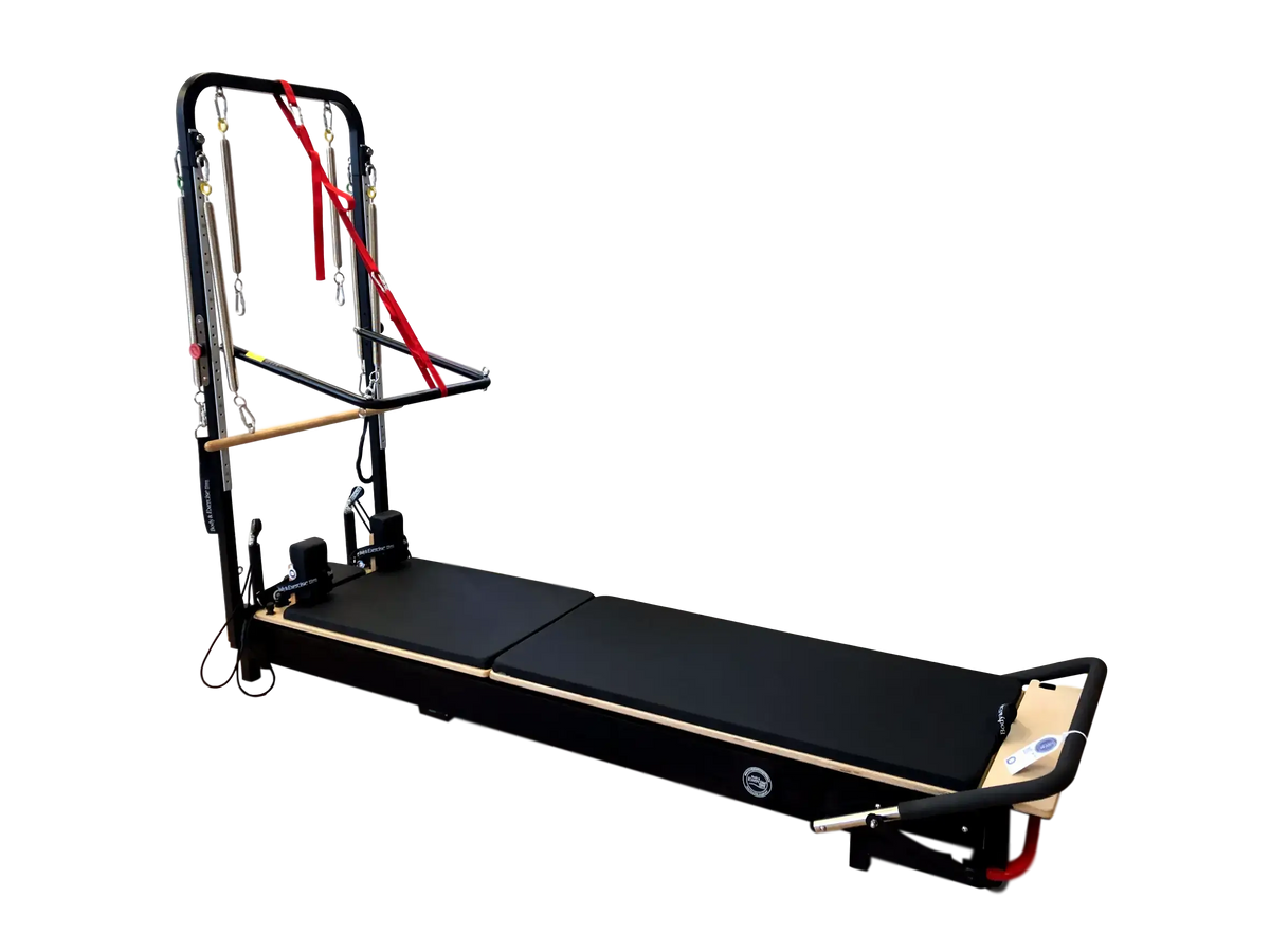 Body & Exercise Reformer Tower Black Edition vor schwarzem Hintergrund, Reformer ausgeklappt mit Turm