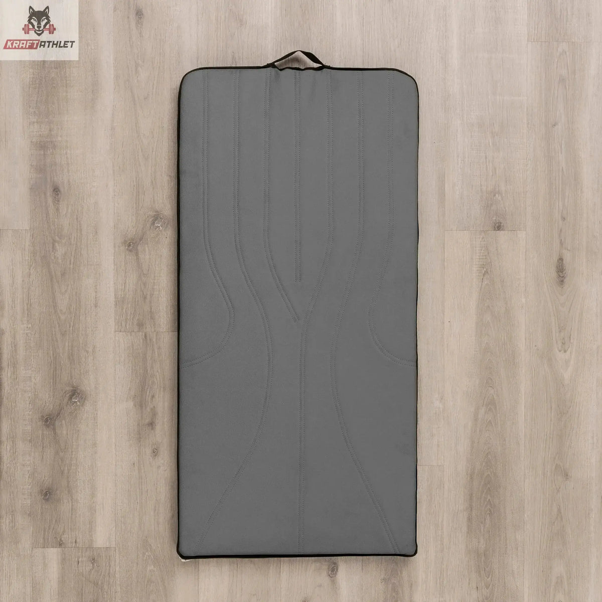 Hegren High Density Pilates-Matte in Grau, Draufsicht auf Holzboden mit Tragegriff am Kopfende