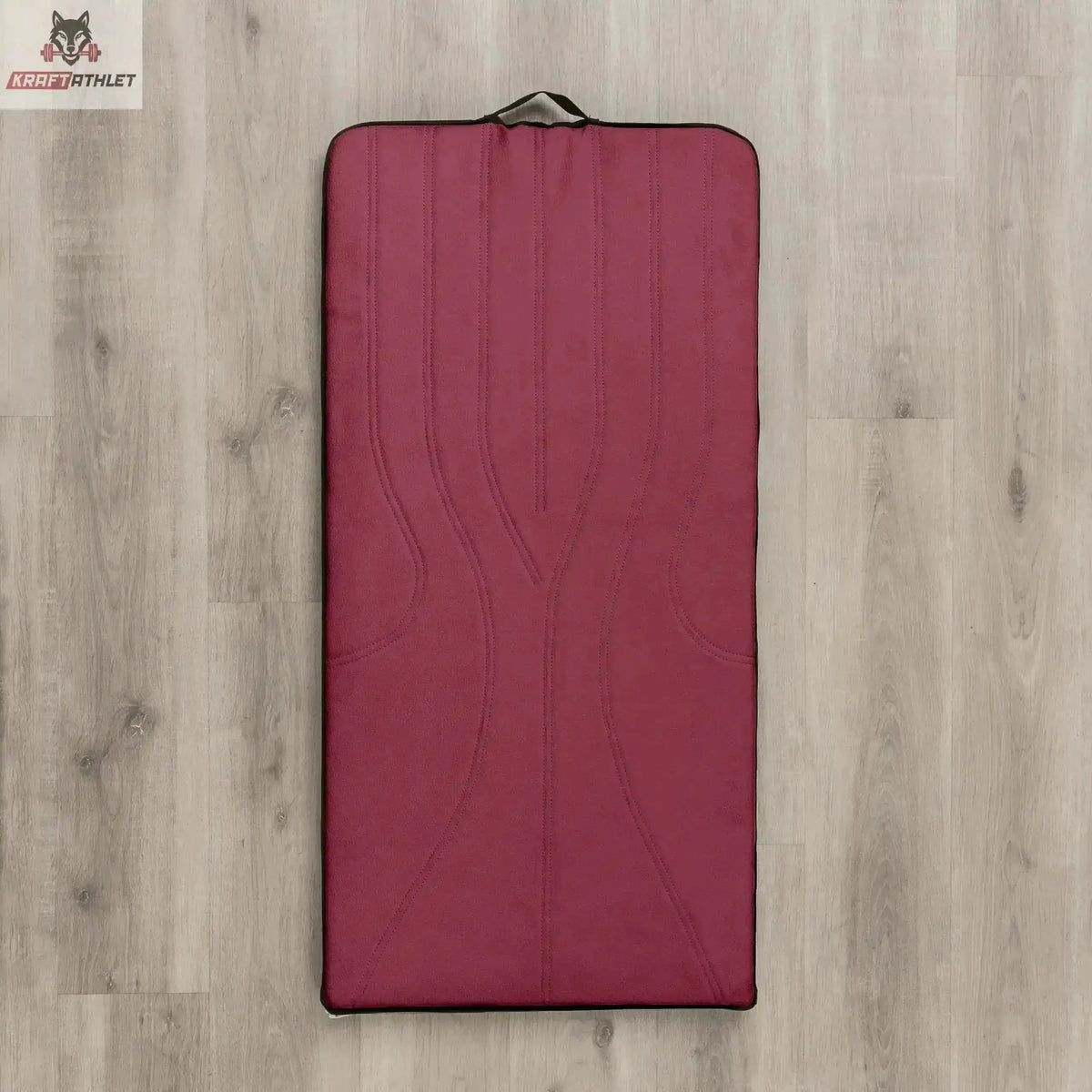 Hegren High Density Pilates-Matte in Puce (Weinrot), Draufsicht auf hellem Holzboden mit Tragegriff