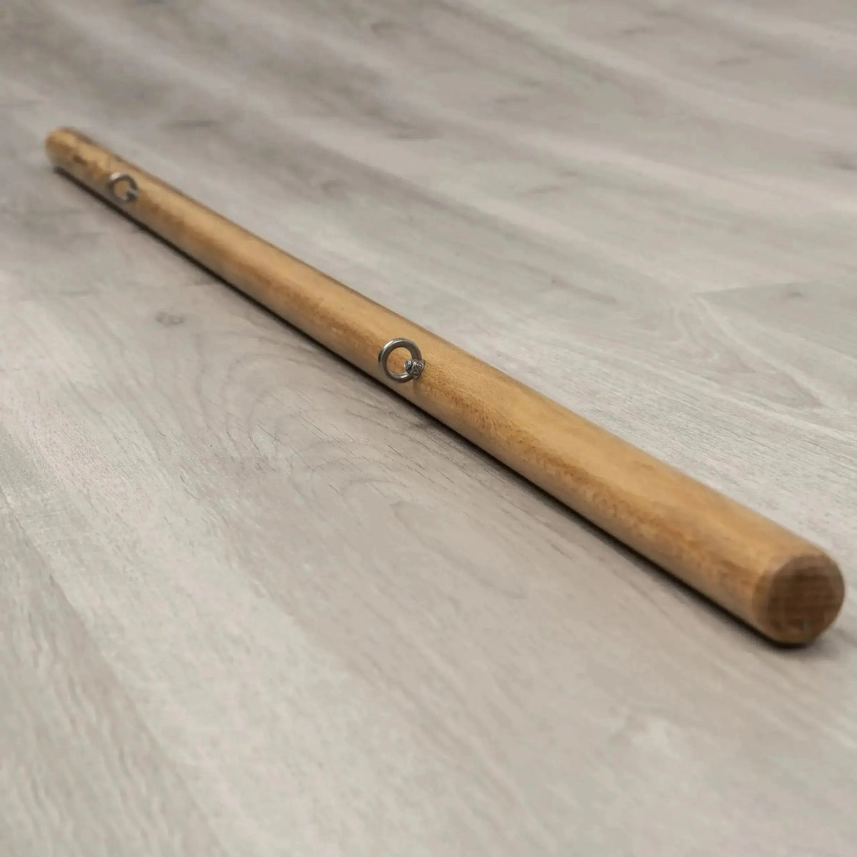 Hegren Pilates Stick 1,10 m mit Verbindungsgliedern aus Holz, Schrägansicht auf hellem Holzboden
