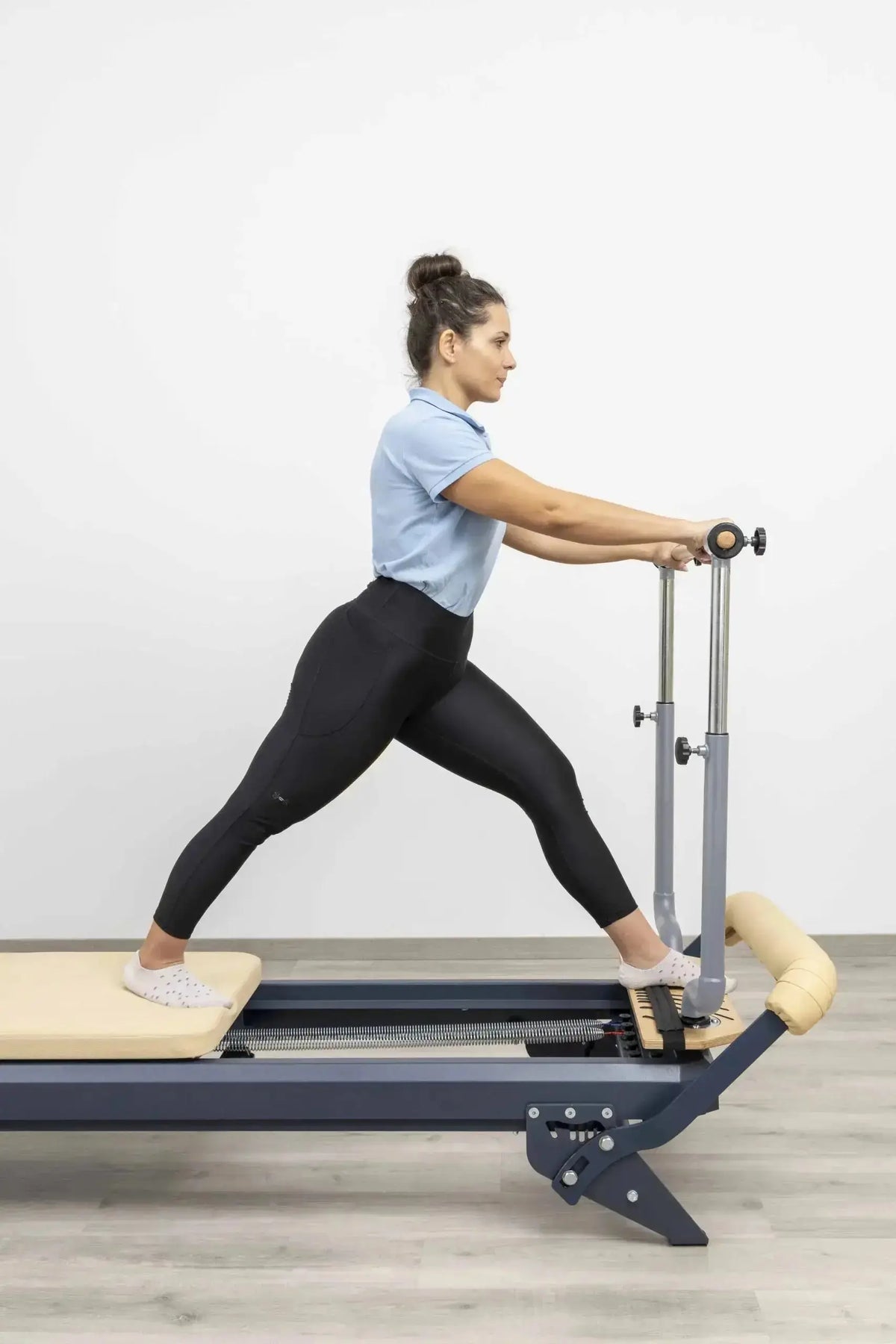 Hegren Stability Bar Wall Stand Wandhalter: Stability Bar am Reformer, Trainierende im Ausfallschritt mit beiden Händen am Griff