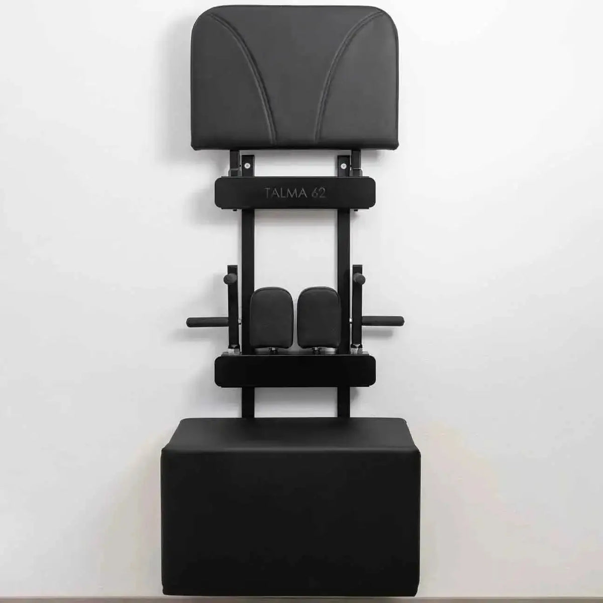 Hegren TALMA 62 Zubehör-Wandhalter aus Stahl in Schwarz an der Wand, beladen mit Rückenpolster und Box