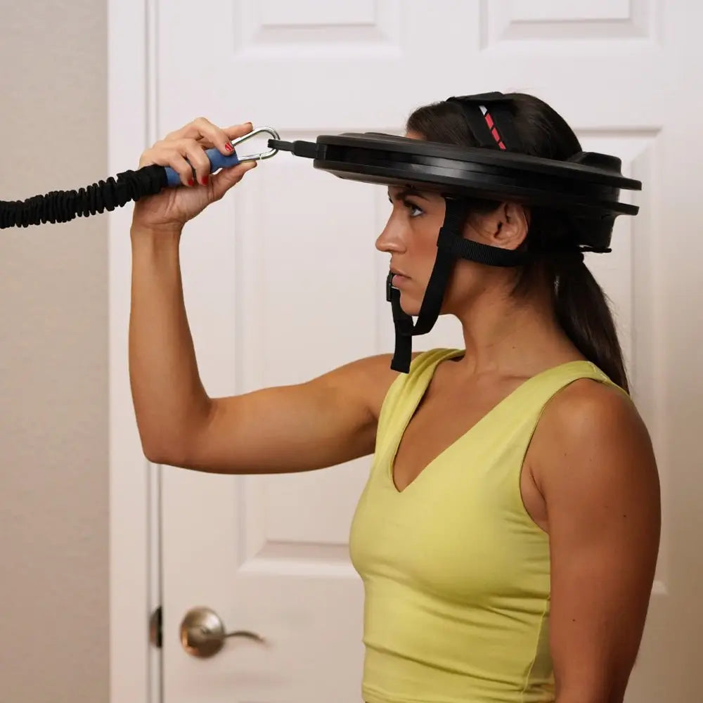 Frau trainiert mit dem Iron Neck 3.0 Nackentrainer, Band an einer Tür befestigt, Seitenansicht zu Hause