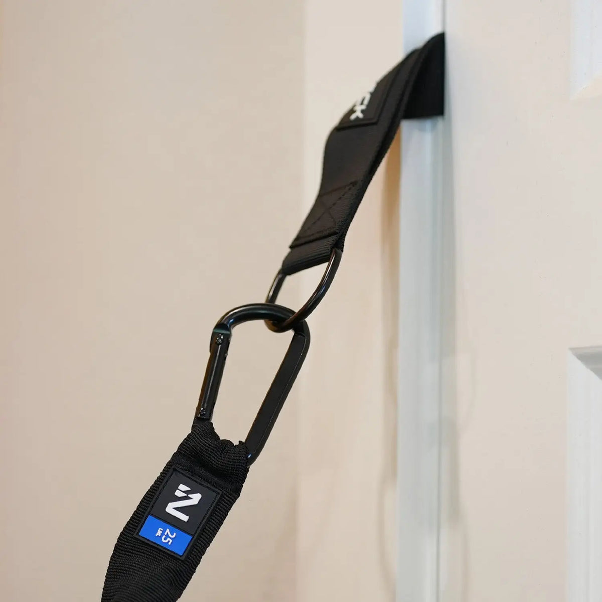 Iron Neck Safe Lock Türanker oben in einer Tür eingeklemmt, Karabiner mit Widerstandsband hängt herab