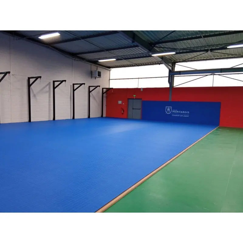 SportCom Flexi-Wall Wandschutz von Dollamur in Blau über blauem und grünem Hallenboden