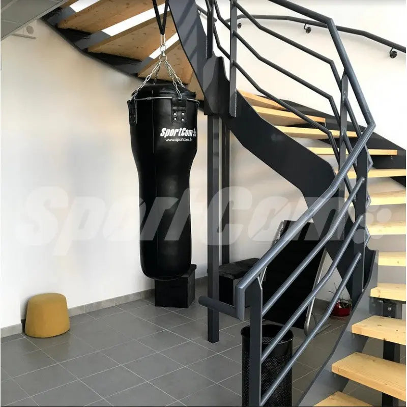 SportCom Kunstleder-Uppercut-Sandsack hängt neben einer Treppe in einem modernen Innenraum