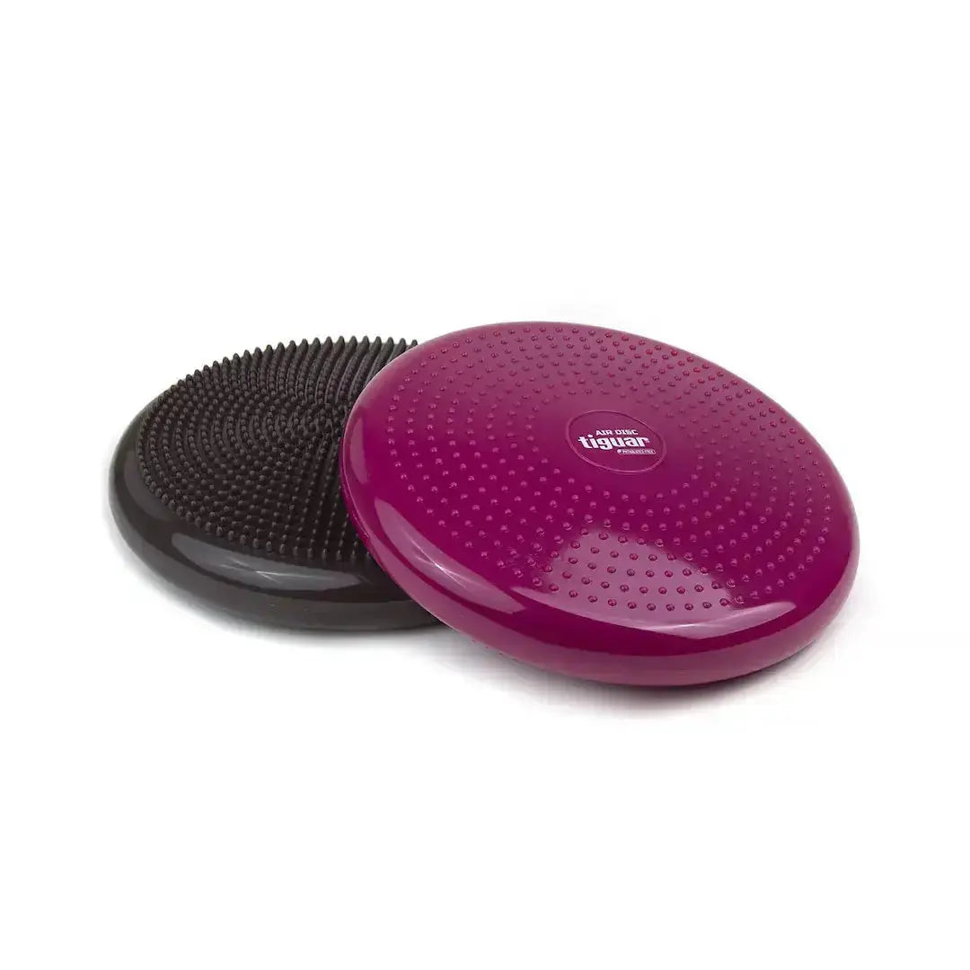 tiguar Air Disc Balancekissen Lila schräg angelehnt an ein schwarzes Kissen, Schrägansicht