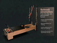 Body & Exercise Reformer Studio Tower P002 aus Holz, Seitenansicht mit Tower und Push-Through-Bar vor dunklem Hintergrund