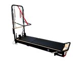 Body & Exercise Reformer Tower Black Edition vor schwarzem Hintergrund, Reformer ausgeklappt mit Turm