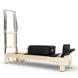 Elina Pilates Classic Reformer mit Tower aus Ahornholz mit Polstern in Schwarz, Seitenansicht vor weißem Hintergrund