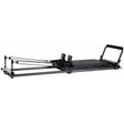Elina Pilates Domo Reformer aus Aluminium in Schrägansicht mit Schlitten, Schulterstützen und Fußstange