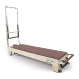 Elina Pilates Elite Reformer mit Tower aus Ahornholz mit Polstern in Altrosa, Schrägansicht mit Tower