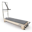 Elina Pilates Elite Reformer mit Tower aus Ahornholz mit Polstern in Grau, Schrägansicht mit Tower und Fußstange