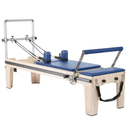 Elina Pilates Master Instructor Physio Reformer aus Ahornholz mit blauen Polstern, Seitenansicht auf Weiß
