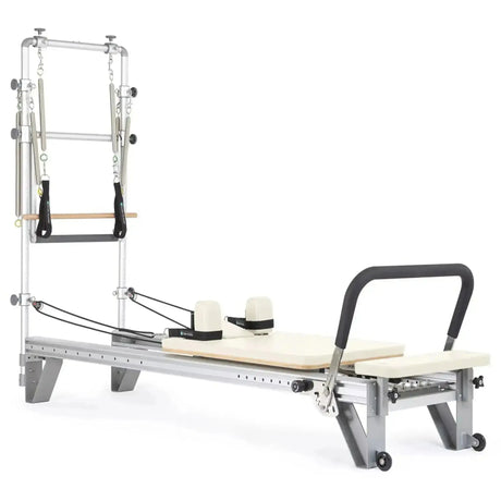 Elina Pilates Mentor Reformer mit Tower aus Aluminium – Schrägansicht mit Polstern in Elfenbein, freigestellt vor weißem Hintergrund
