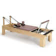Elina Pilates Wooden Reformer aus Rock-Ahorn in Altrosa, Schrägansicht mit Fußstange und Schulterstützen