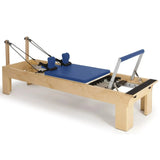 Elina Pilates Wooden Reformer aus Rock-Ahorn in Blau, Schrägansicht mit Holzrahmen und Fußstange