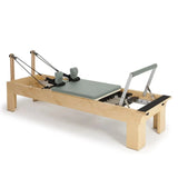 Elina Pilates Wooden Reformer aus Rock-Ahorn in Eukalyptus, Schrägansicht mit Holzrahmen und Fußstange