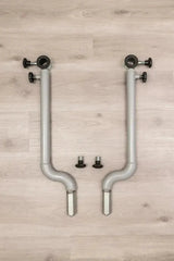Hegren Stability Bar Wall Stand Wandhalter: zwei einzelne Stability Bars mit Stellschrauben liegend auf Holzboden