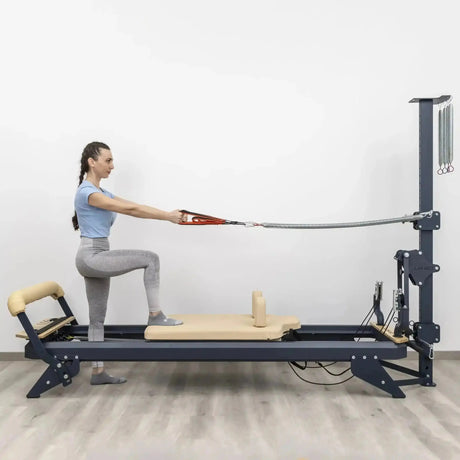 Hegren TALMA 62CT+ Reformer mit Tower, Frau im Ausfallschritt auf dem Schlitten mit Seilzug