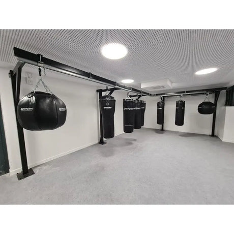 SportCom Birnenförmiger Uppercut-Sandsack Echtleder an einem Stahlgerüst in einem hellen Trainingsraum