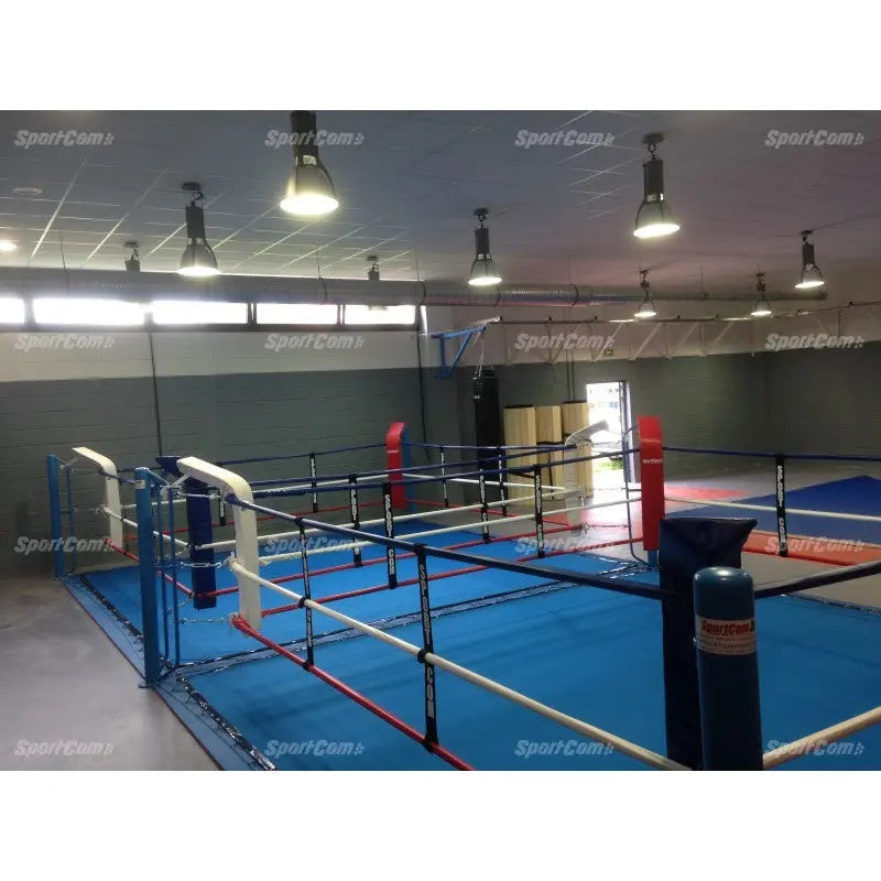 SportCom Doppel-Boxring Bodenpfosten mit Spannseilen, in einer Halle mit roter und blauer Ecke