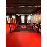 SportCom Ecofix Bodenmontage-Boxring mit Aluminiumrand, in einem Gym mit rotem Boden und hohen Fenstern