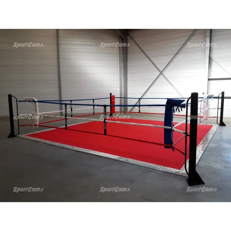 SportCom Ecofix Bodenmontage-Boxring mit Aluminiumrand, mit rotem Boden und blauer Ecke in einer Halle