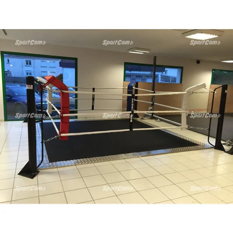 SportCom Ecofix Bodenmontage-Boxring mit Aluminiumrand, in einem Raum mit Fliesenboden und roter Ecke