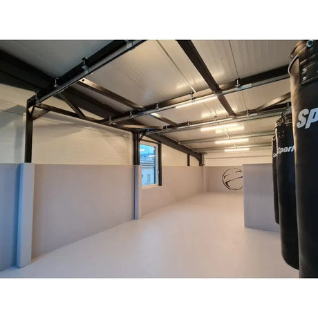 SportCom Flexi-Post Säulenpolster von Dollamur in Hellblau an Säulen einer Halle mit Boxsäcken