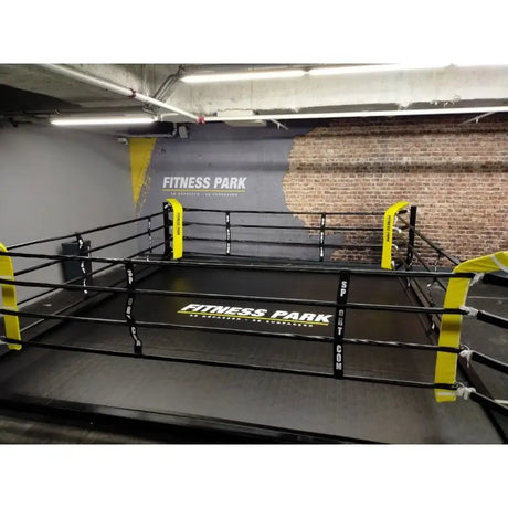 SportCom Flexi-Roll Mattenfläche für Boxringe in einem Ring mit gelben Eckpolstern im Fitnessstudio