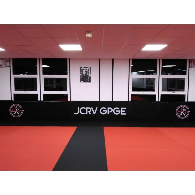 SportCom Flexi-Wall Wandschutz von Dollamur in Schwarz mit Schriftzug an der Fensterwand eines Dojos