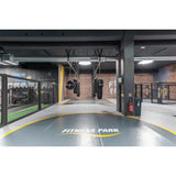 SportCom Flexi-Wall Wandschutz von Dollamur in Grau in einem Gym mit Käfig und Bodenmarkierung