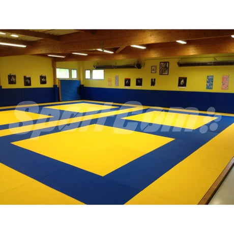 SportCom Judo-Tatami Reisstroh 1 × 1 m, 5 cm, rutschfeste Unterseite, gelbe Felder auf blauer Fläche vor gelben Wänden