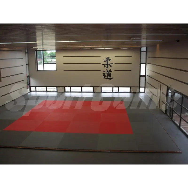 SportCom Judo-Tatami Reisstroh 2 × 1 m, 5 cm, glatte Unterseite, rote Fläche mit grauem Rand im Dojo mit Kanji an der Wand