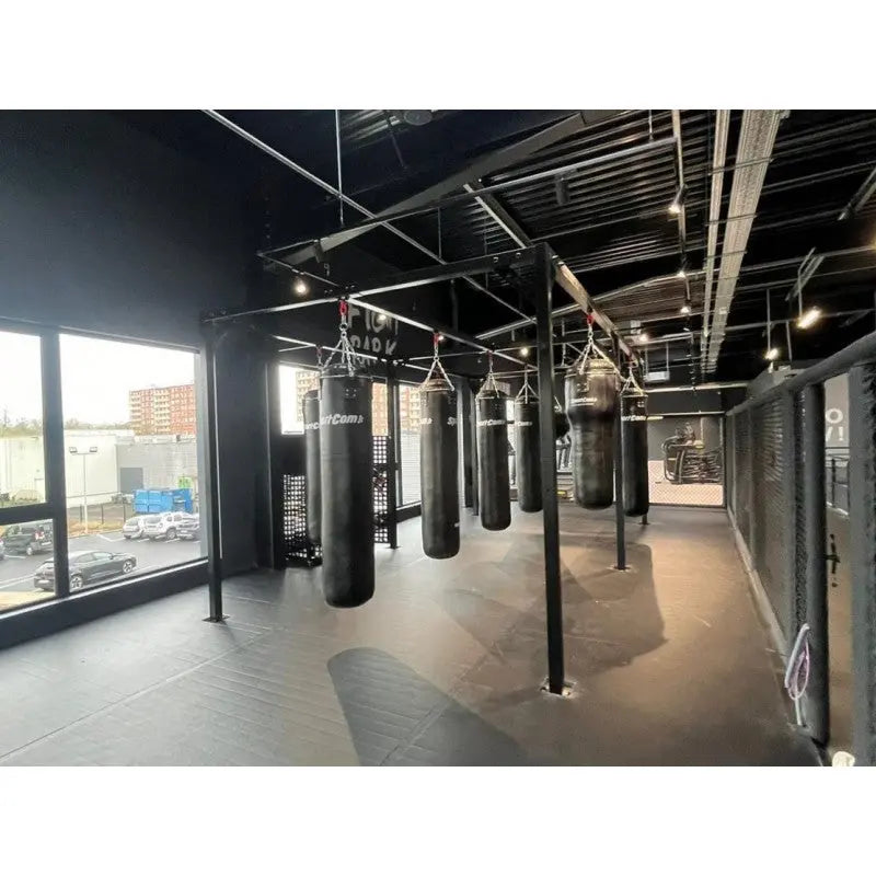 SportCom Kunstleder-Sandsack 1,80 m in Reihe an Fensterfront eines Industriestudios