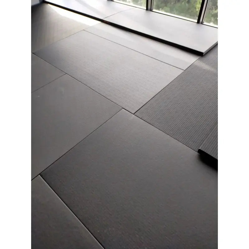 SportCom MMA-Tatami Glattfinish 1 × 1 m, 4 cm, rutschfeste Unterseite, Nahaufnahme verlegter grauer Matten am Fenster