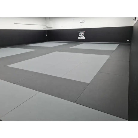 SportCom MMA-Tatami Glattfinish 1 × 1 m, 4 cm, rutschfeste Unterseite, Studio mit hellgrauen Feldern auf dunklem Grund