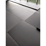 SportCom MMA-Tatami Glattfinish 1 × 1 m, 5 cm, glatte Unterseite, Nahaufnahme verlegter grauer Matten am Fenster