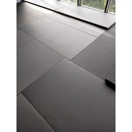 SportCom MMA-Tatami Glattfinish 1 × 1 m, 5 cm, glatte Unterseite, Nahaufnahme verlegter grauer Matten am Fenster