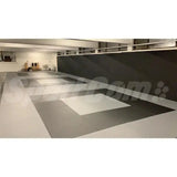SportCom MMA-Tatami Glattfinish 1 × 1 m, 5 cm, glatte Unterseite, Halle mit dunkelgrauer Fläche und hellem Feld