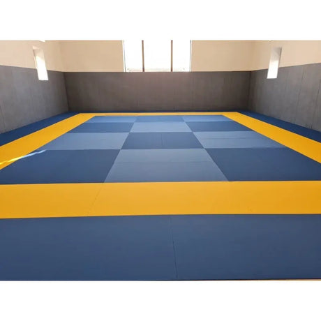 SportCom MMA-Tatami Glattfinish 1 × 1 m, 5 cm, glatte Unterseite, Halle mit blau-grauem Schachbrett und gelbem Rand