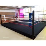 SportCom Pro-Trainingsboxring mit 30 cm Podium, in einem Studio mit bunten Glaswänden