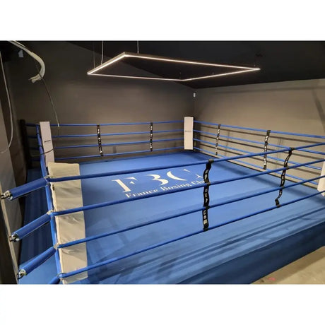 SportCom Pro-Trainingsboxring mit 30 cm Podium, mit blauem Boden und Logo im Studio mit LED-Licht