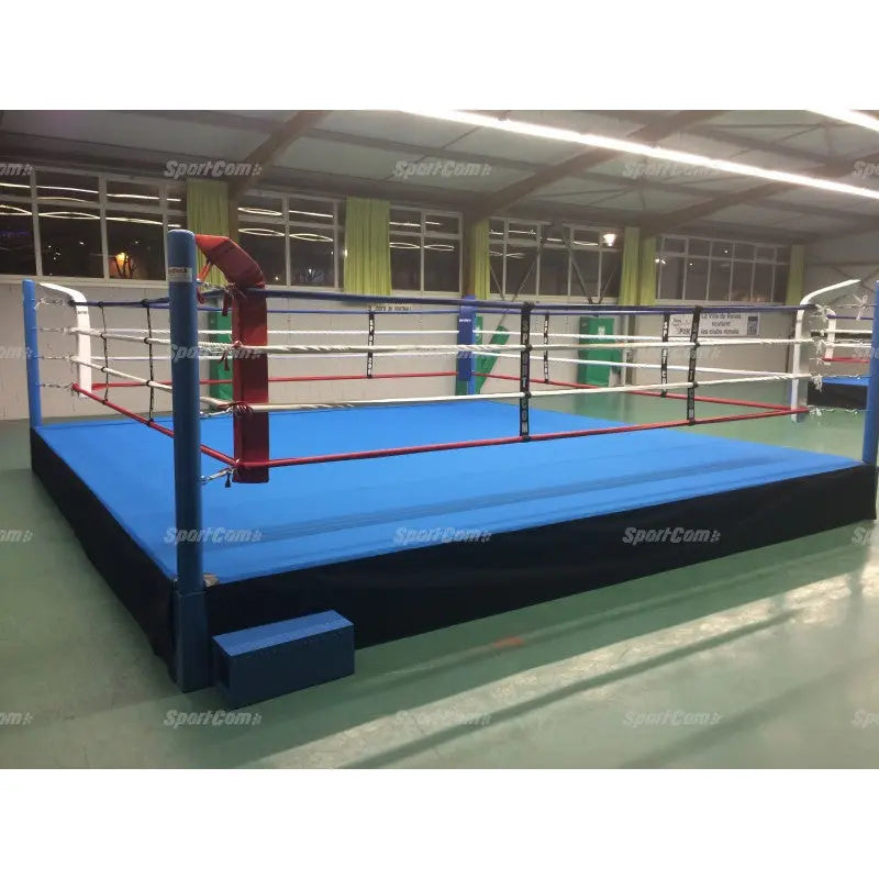 SportCom Pro-Trainingsboxring mit 50 cm Podium, mit blauem Boden und roter Ecke in einer Halle