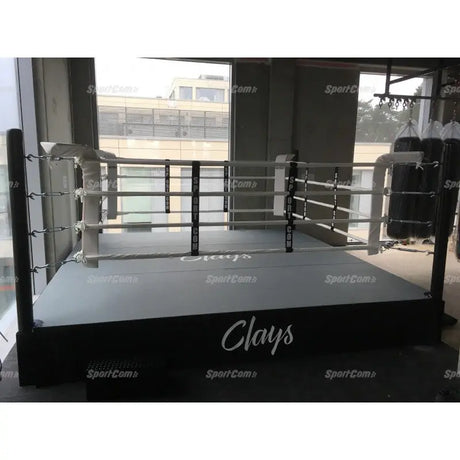 SportCom Pro-Trainingsboxring mit 50 cm Podium, in einem Studio mit weißen Ecken und Fensterfront