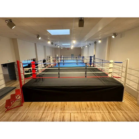 SportCom Pro-Wettkampf-Boxring mit 1 m Podium, in einer hellen Halle mit Holzboden
