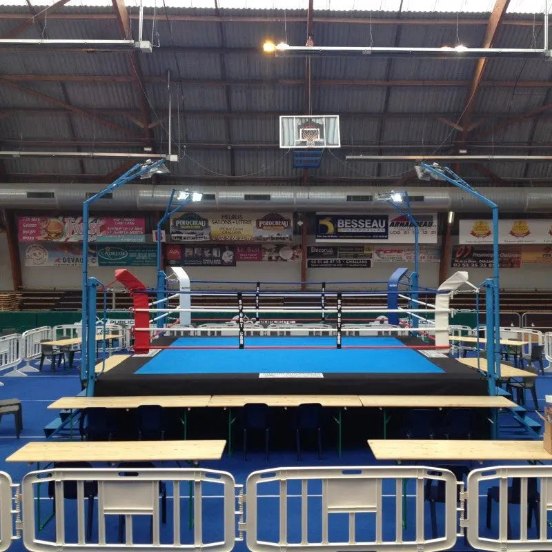 SportCom Pro-Wettkampf-Boxring mit 1 m Podium, in einer Sporthalle mit Kampfrichtertischen
